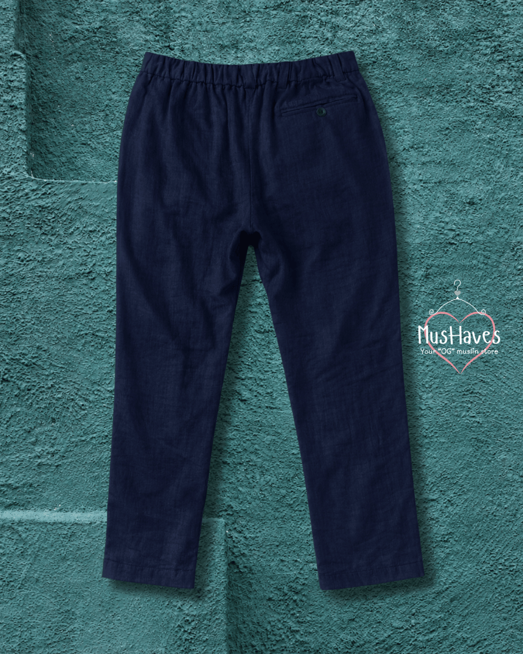 Navy blue pants on a textured teal background with 'Hush Haves' branding.